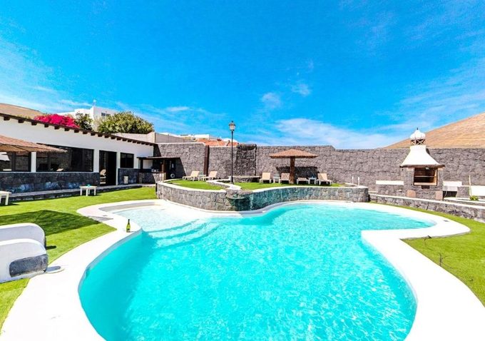 Casa Rural Islas Canarias La Asomada Lanzarote — bright turquoise swimming pool with sun loungers at a rural apartment complex with volcano views