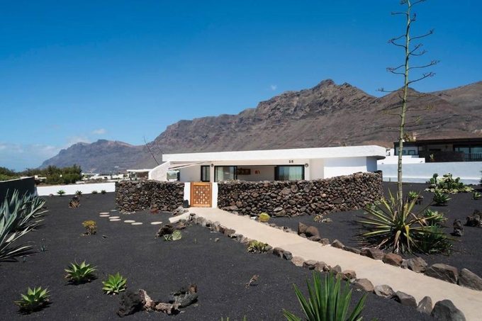 Lanzarote Famara Beach Bungalow Caleta de Famara — beachfront bungalow with outdoor pool, sun loungers, and views of the Risco de Famara cliffs