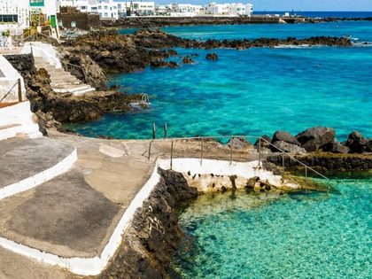 Punta Mujeres Lanzarote — natural volcanic rock pools along the coast of a small whitewashed fishing village on the northeast of the island, with crystal-clear turquoise water and stepped concrete platforms