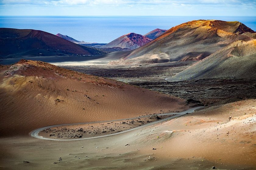 Timanfaya National Park Lanzarote — rust-red volcanic crater landscape with Fire Mountains route under bright blue sky